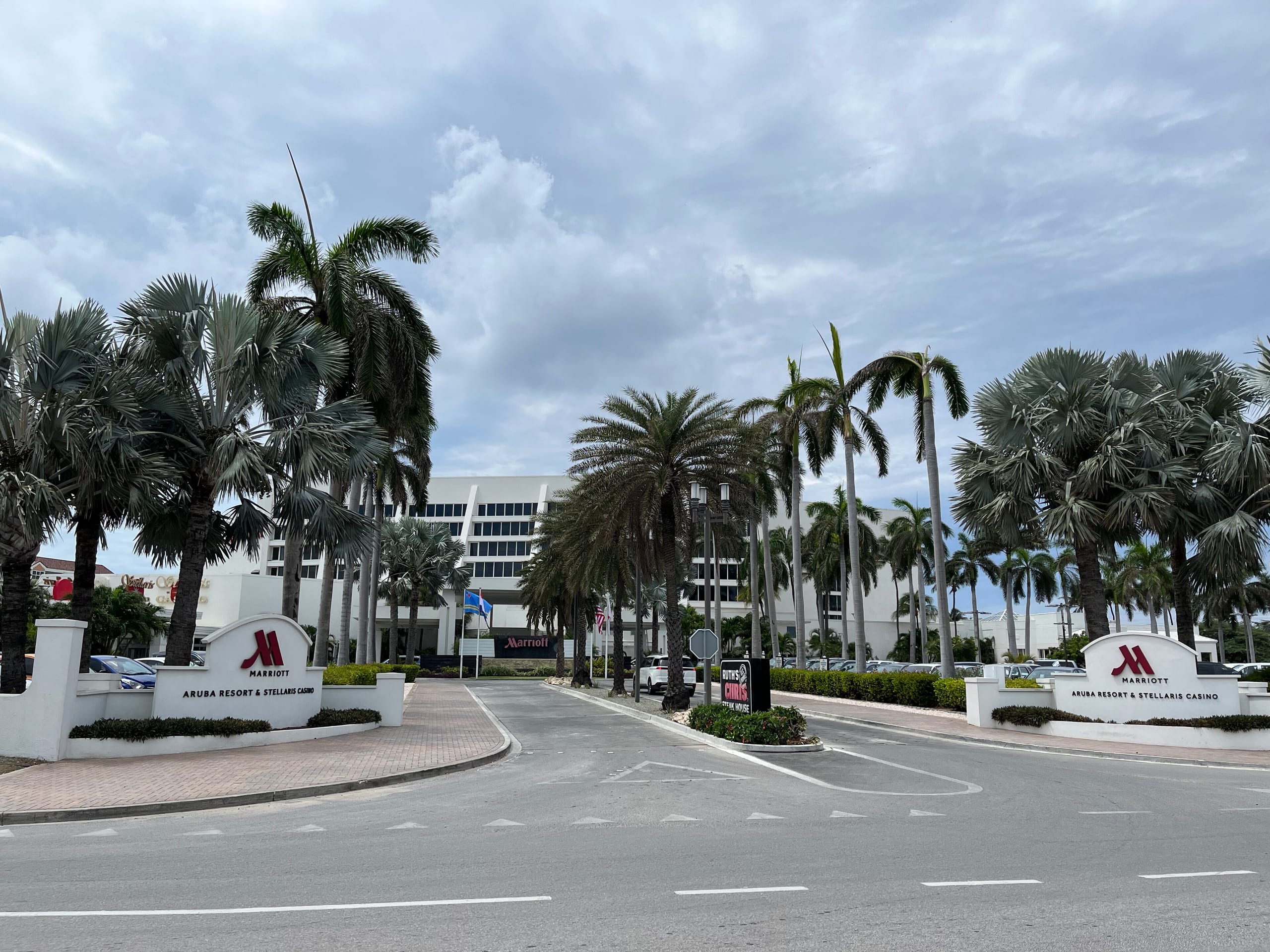 The palm-lined entrance and signs of the Aruba Marriott Resort and Stellaris Casino on Palm Beach, Aruba