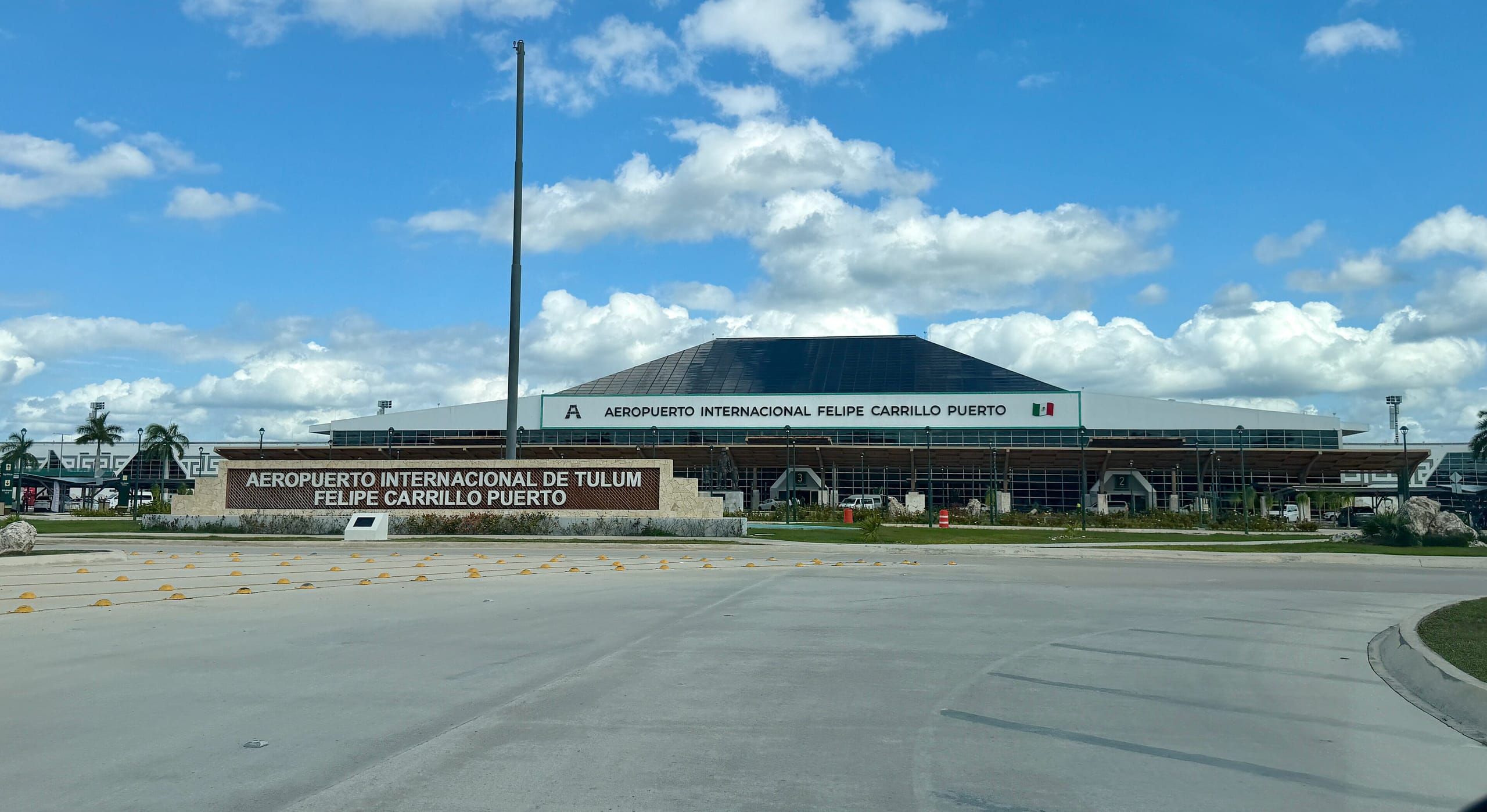 Tulum International Airport terminal front under a blue sky with its entrance sign