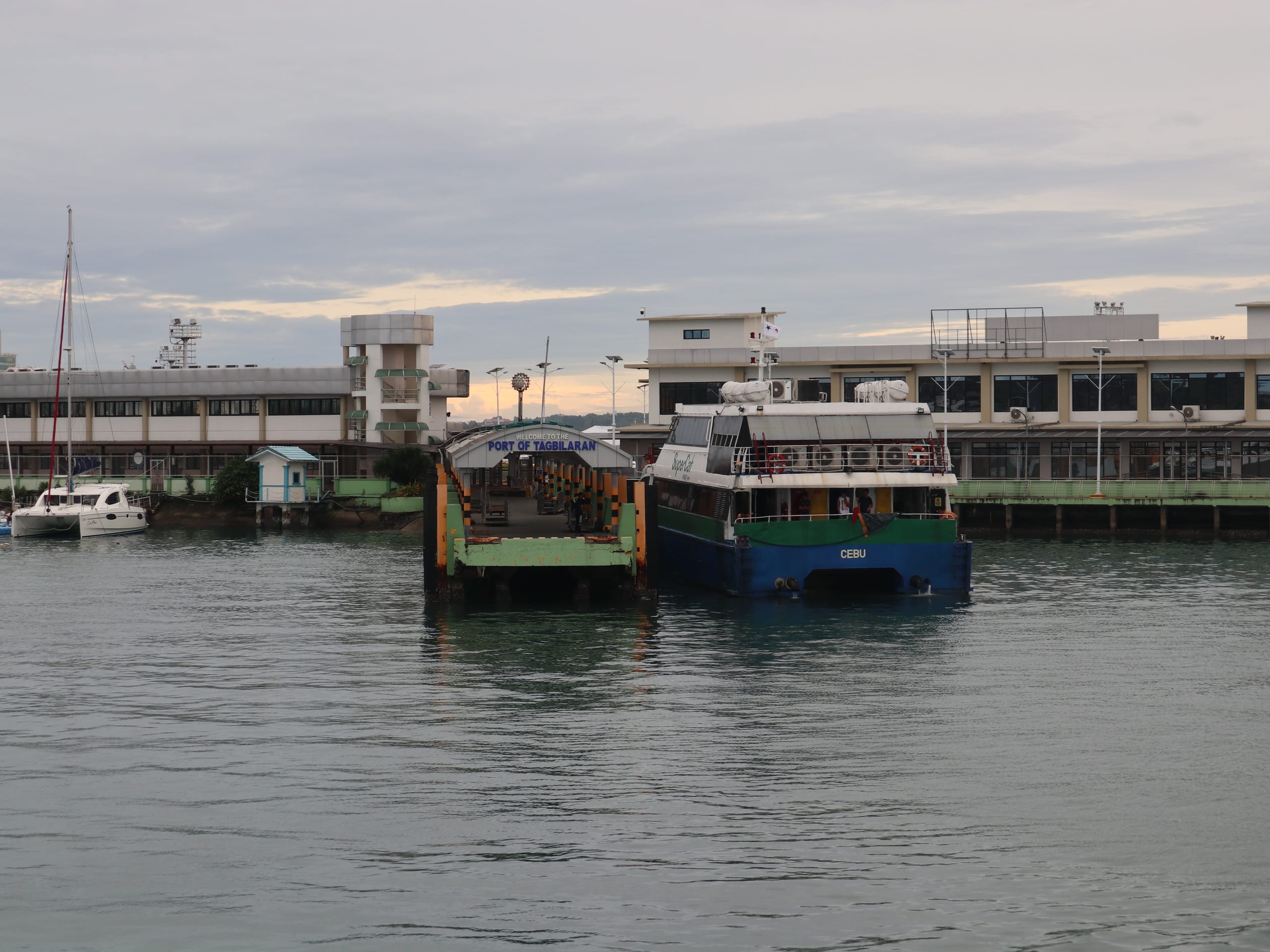 Ferry docked beside the Port of Tagbilaran welcome arch at dusk, Bohol