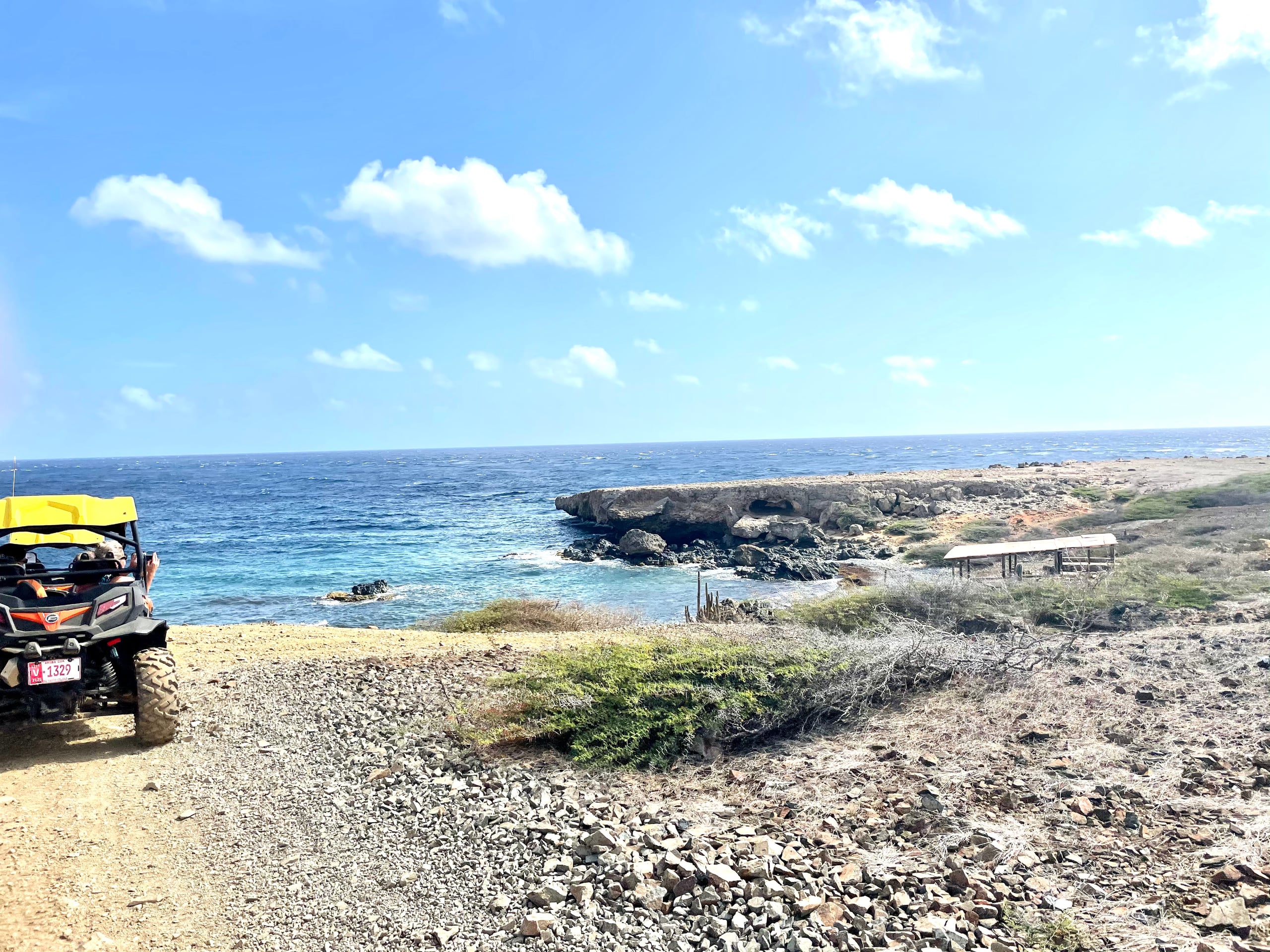 An off-road buggy parked on the rocky windward coast inside Arikok National Park