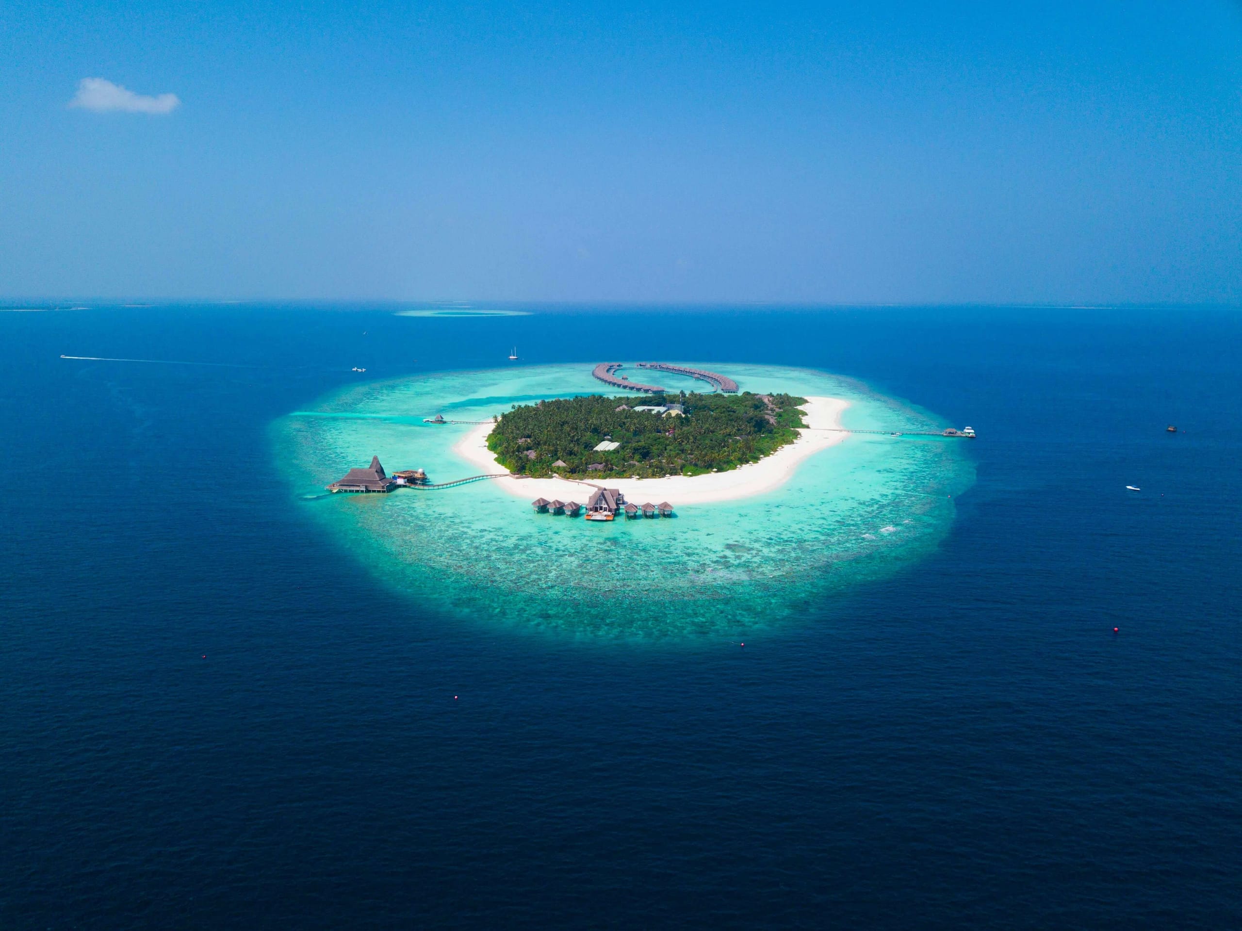 Aerial view of a resort island ringed by a turquoise lagoon